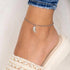 Woman Wearing White Enamel Angel Wing Anklet
