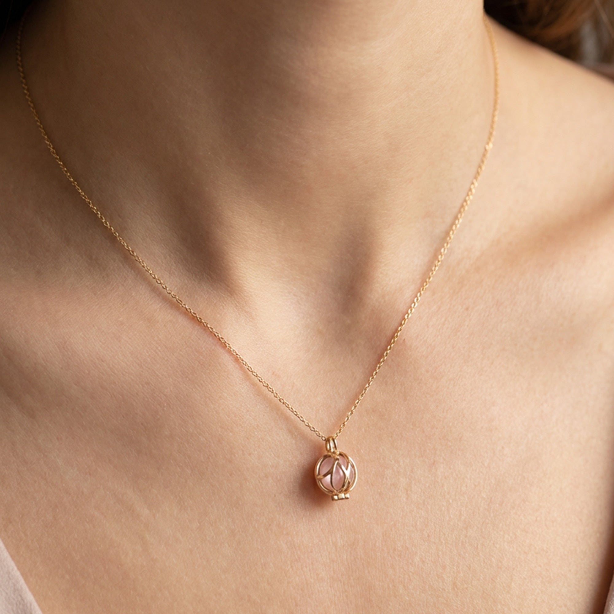 Woman Wearing Rose Quartz Infinity Cage Gold Necklace