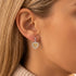 Woman wearing Engelsrufer heart filigree flower of life silver gold earrings.