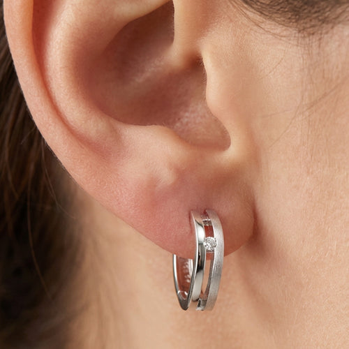 Close Up Woman Wearing Sterling Silver Twist 16mm Hoop CZ Earrings
