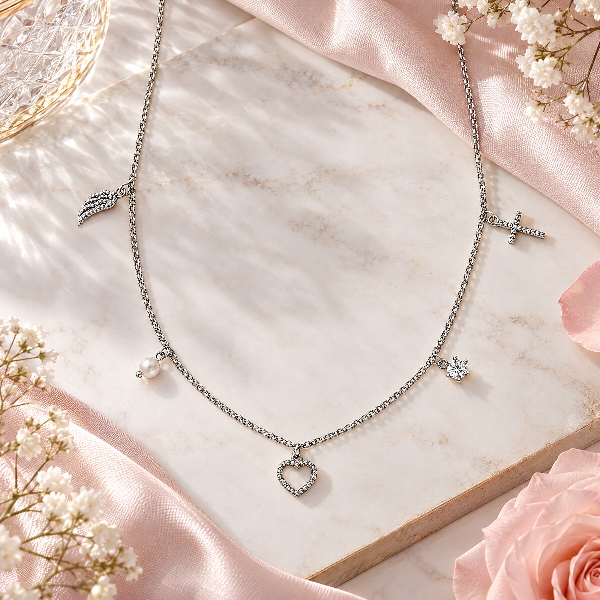 Engelsrufer faith love hope sterling silver charm necklace on a marble slice.