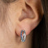Woman Wearing Sterling Silver Ocean Blue Infinity Paradise CZ Hoop Earrings