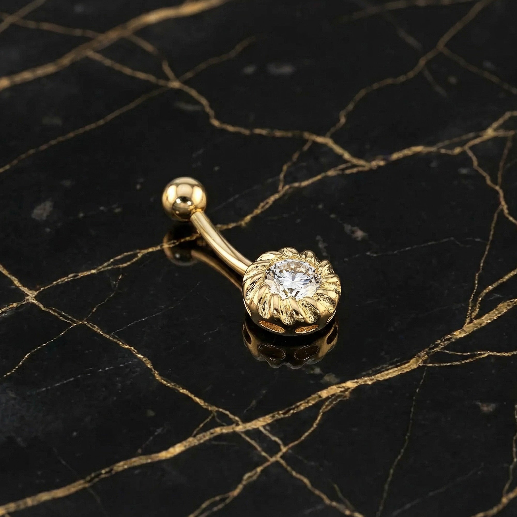 14 Carat Solid Gold CZ Belly Bar Piercing on Marble Table With Gold Seam