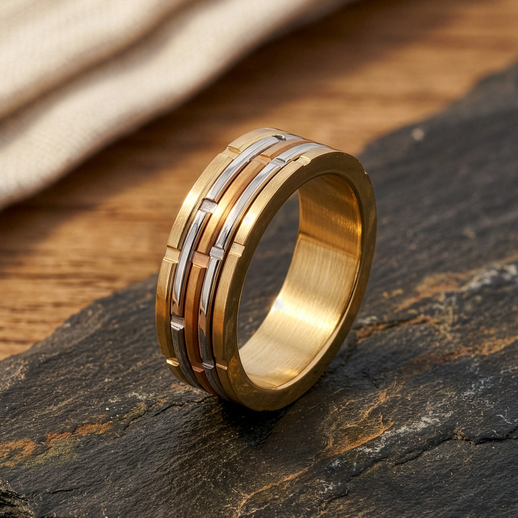 Stainless Steel Gold Notched Band Ring Sitting On Stone