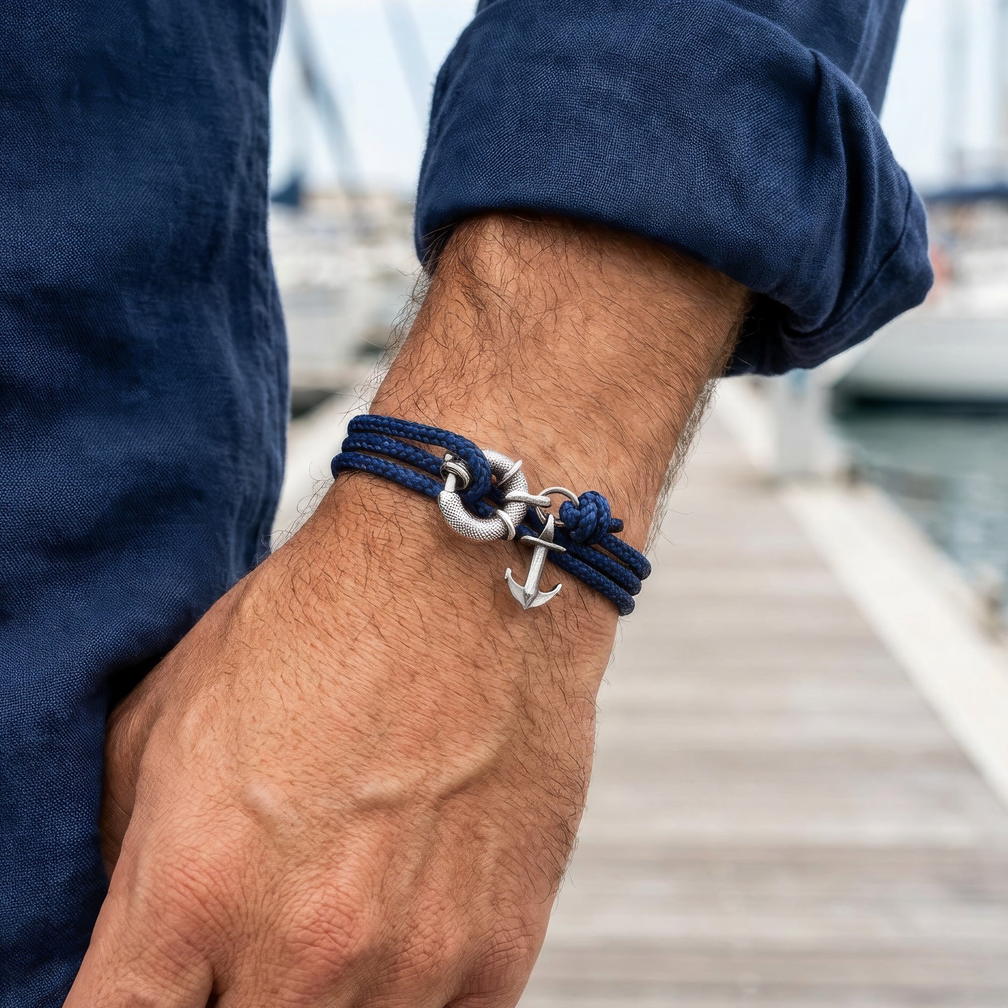 Man wearing Anchor & Crew Clyde sterling silver navy blue rope bracelet on wrist.