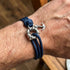 Close-up of man wearing Anchor & Crew Clyde sterling silver navy blue rope bracelet on wrist.
