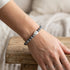 Woman wearing Anchor & Crew coffee bean silver grey jasper stone bracelet