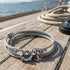 Anchor & Crew Clyde sterling silver grey rope bracelet on jetty with compass and rope.