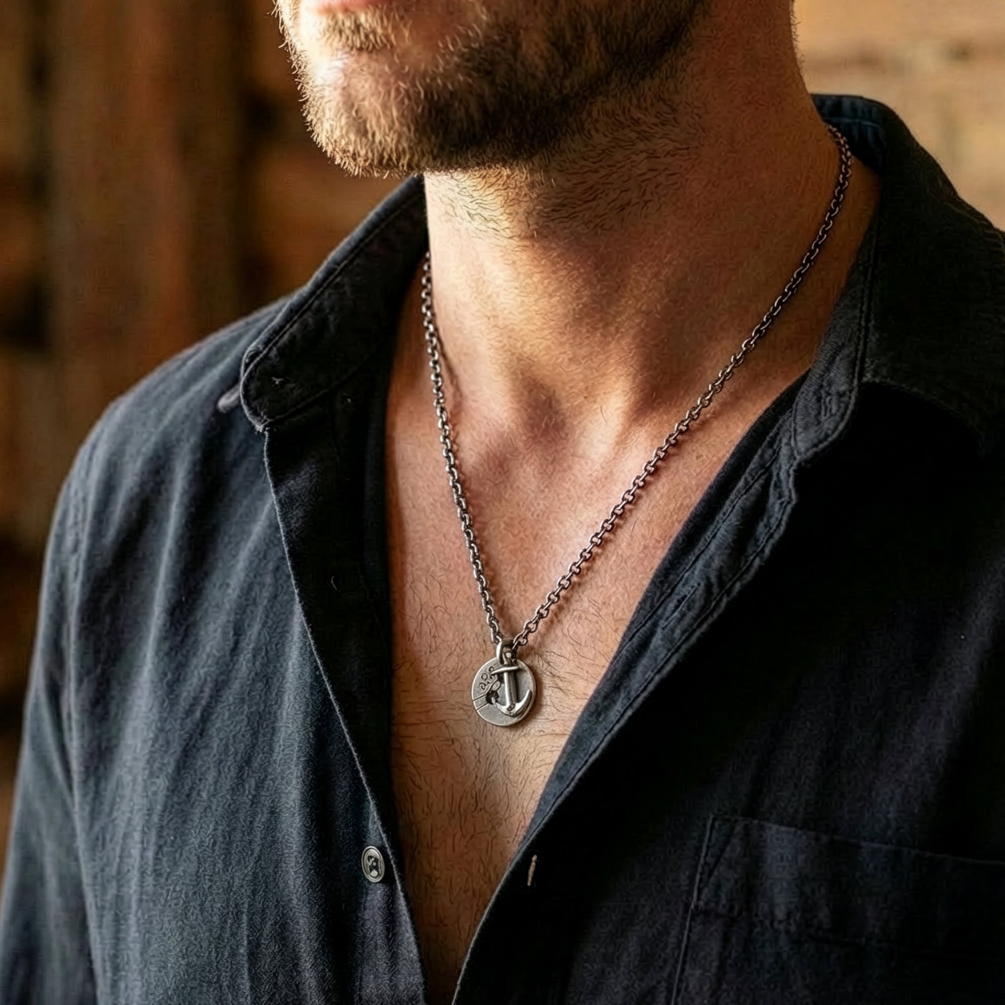 Close-up of a man wearing an Anchor & Crew Lerwick pulley and anchor sterling silver necklace.