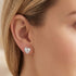 Woman wearing Engelsrufer angel wing heart silver CZ stud earrings.