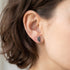 Woman wearing Engelsrufer little angel wing marcasite silver CZ stud earrings.