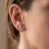 Woman wearing Engelsrufer angel wing crystal pave rose gold stud earrings.