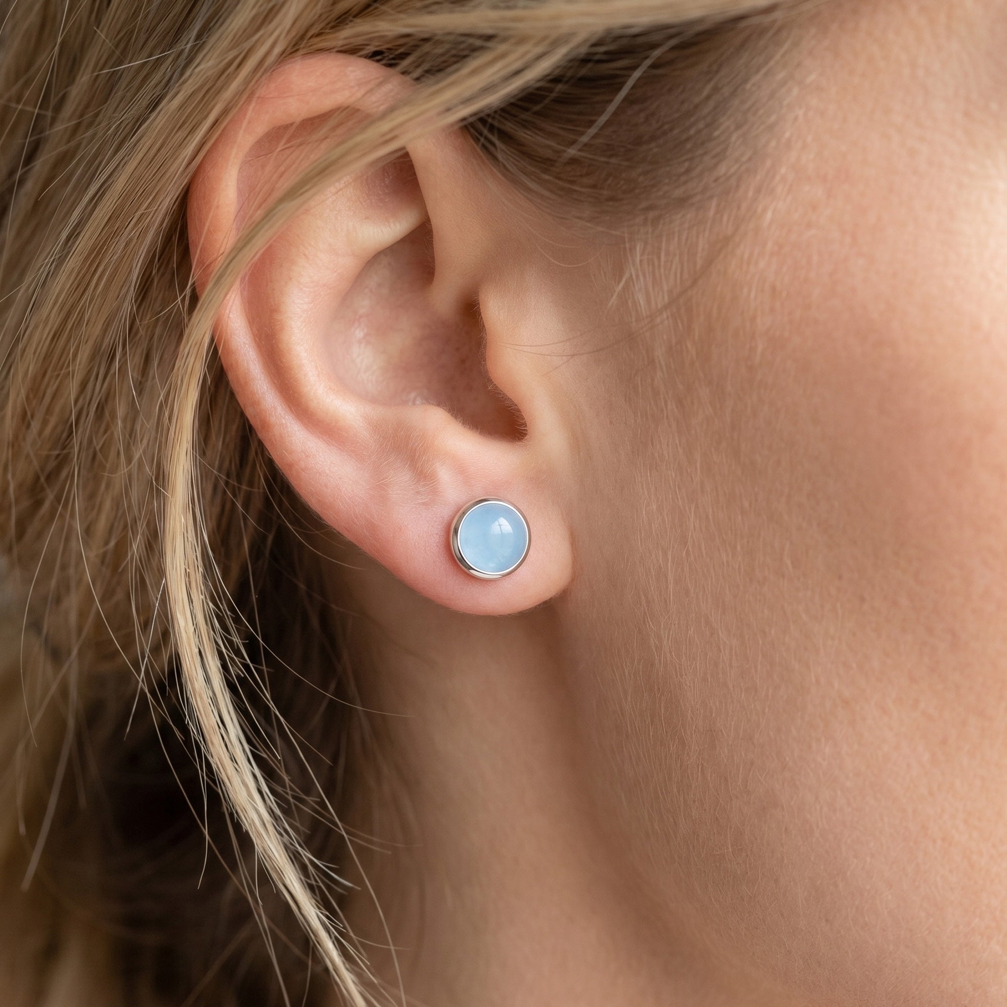 Woman wearing Engelsrufer aquamarine cabochon silver stud earrings.