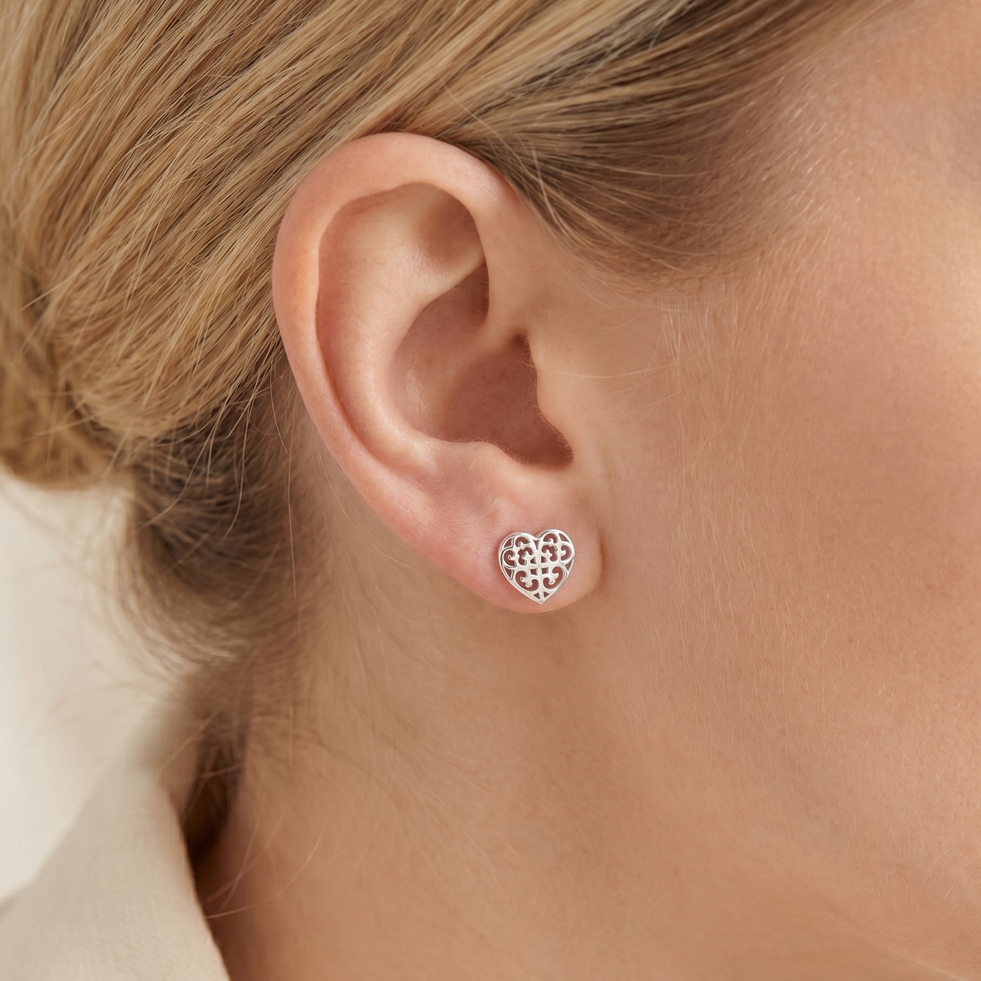 Woman wearing Engelsrufer Arabesque heart filigree silver stud earrings.