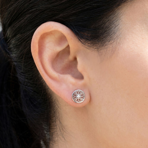 Woman wearing Engelsrufer Arabesque round filigree silver stud earrings.