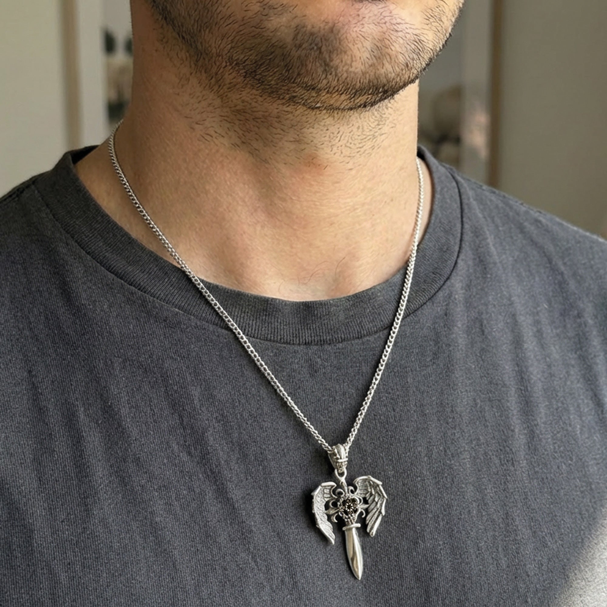 Close-up side view of man wearing an Archangel Michael sword silver necklace.