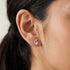 Woman wearing Engelsrufer balance yin yang mini silver earrings.