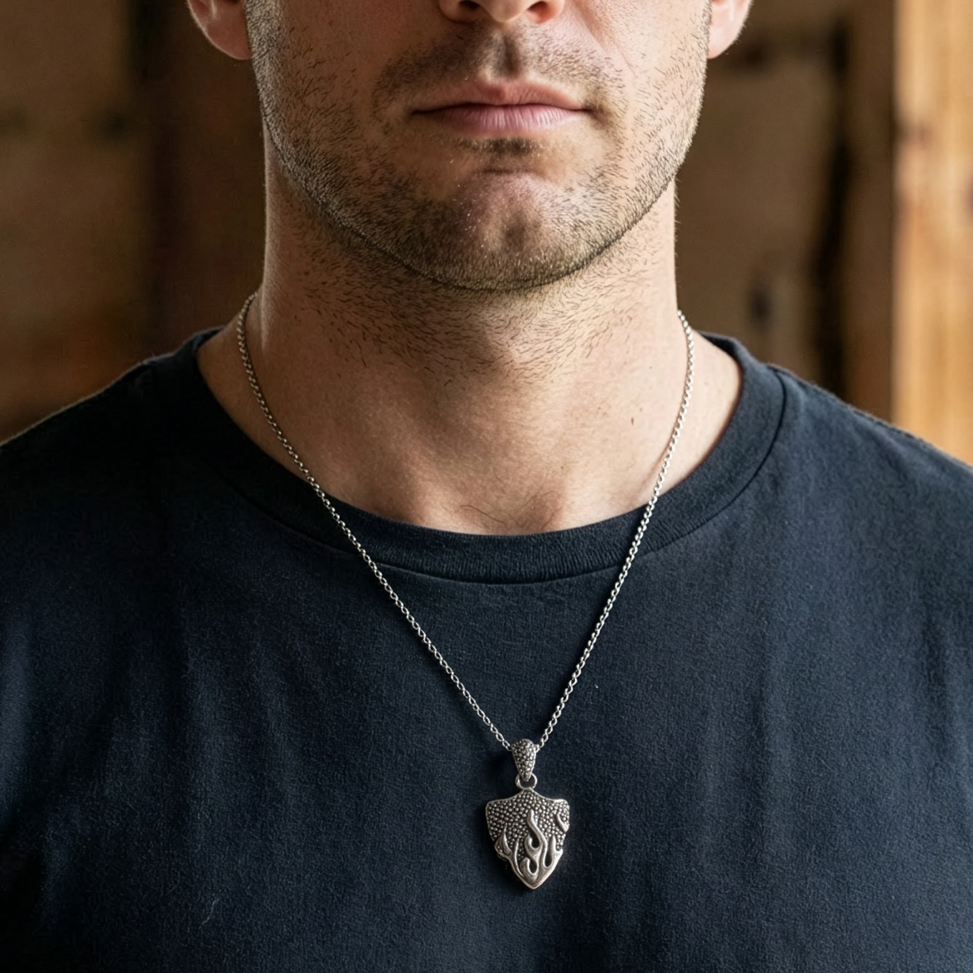 Man wearing a battle flames shield stainless steel necklace.