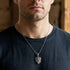 Man wearing a battle flames shield stainless steel necklace.