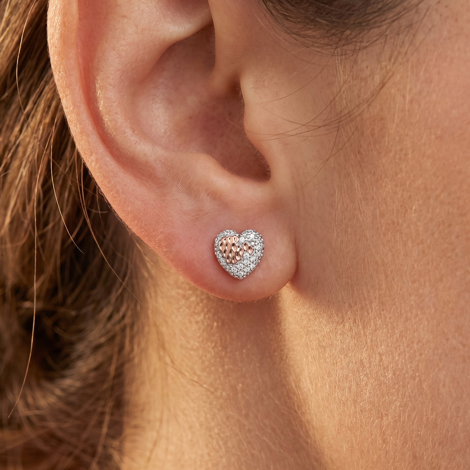 Woman wearing Engelsrufer beating heart of love stud earrings.