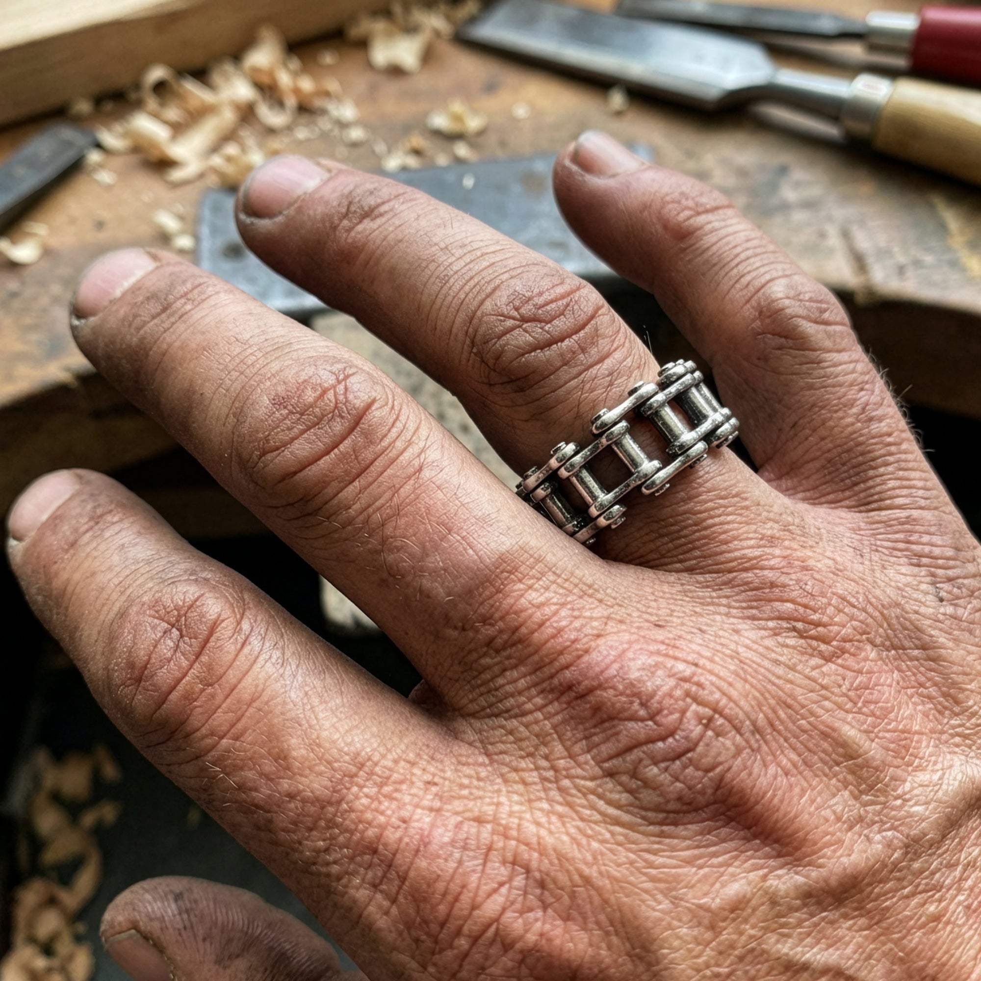 Close-up of a man lwearing a stainless steel men's industrial bike chain ring.