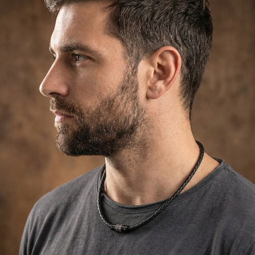 Man looking left wearing Save Brave black braided leather men's bead necklace.