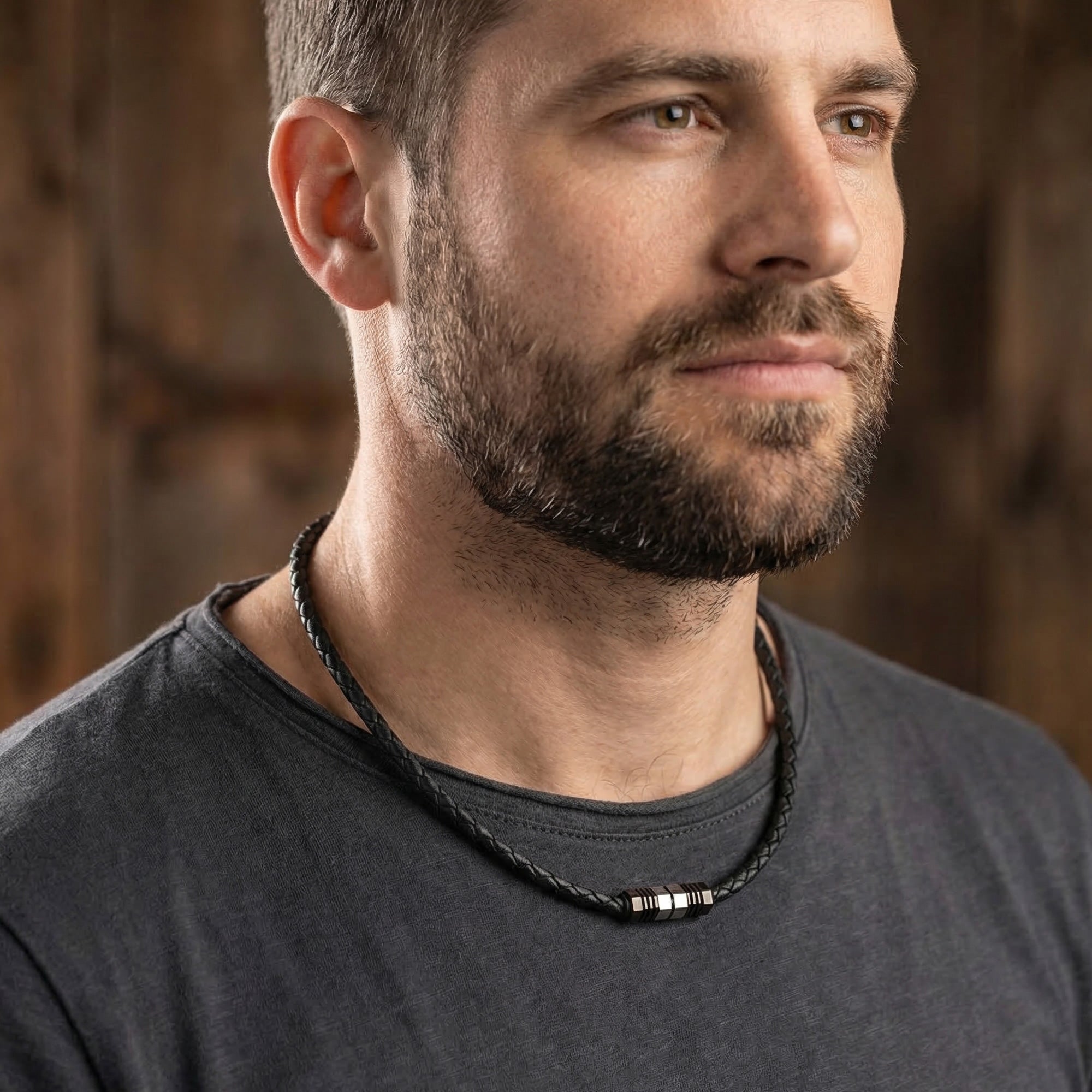 Man looking right wearing Save Brave black braided leather men's bead necklace.