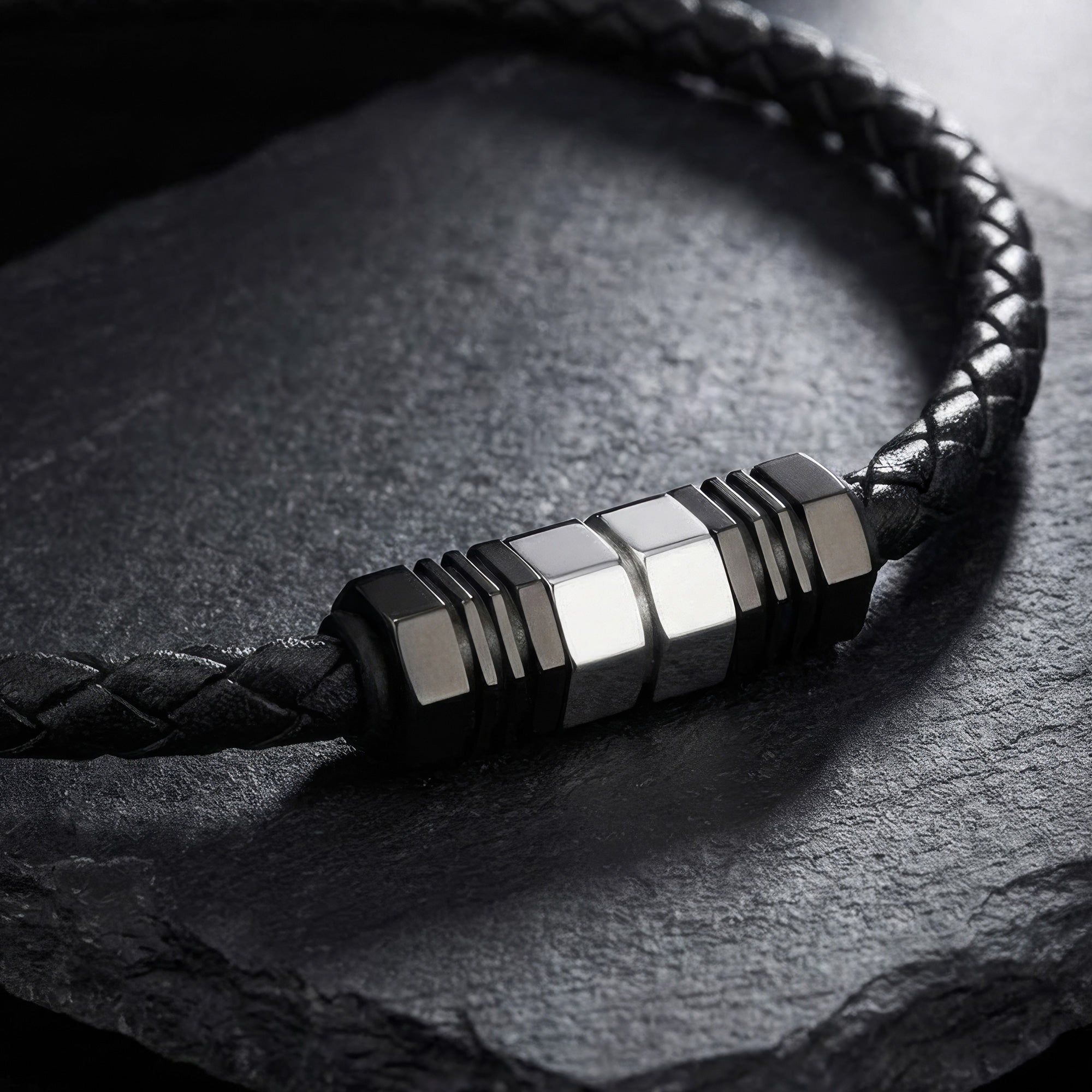 Close-up of Save Brave black leather men's bead necklace on a black stone surface.