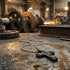 Black rivet cross stainless steel men's necklace on a factory bench with equipment and sparks in the background.