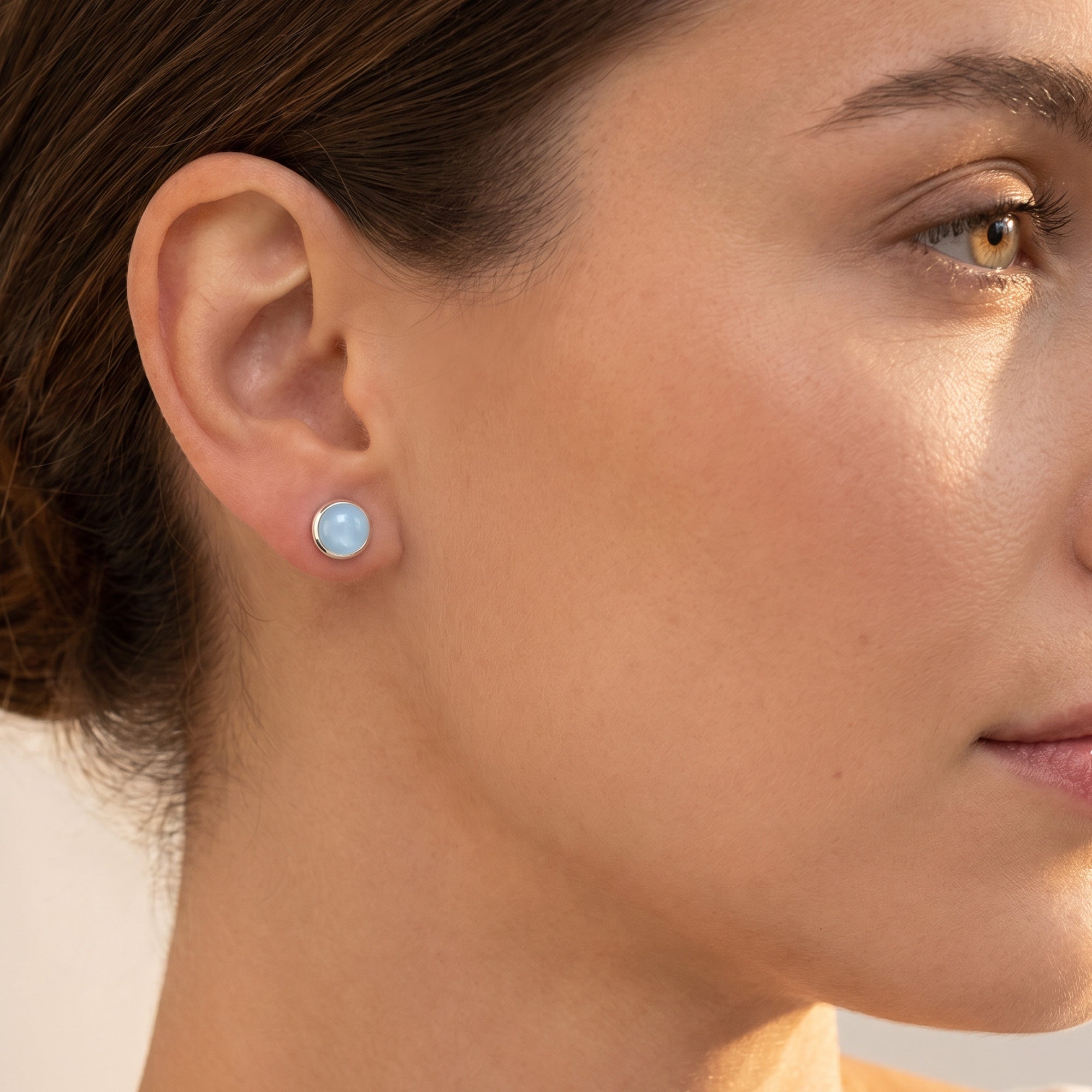 Woman wearing Engelsrufer blue agate cabochon silver stud earrings.