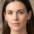 Woman wearing a pair of Engelsrufer aqua blue CZ hoop dangle earrings.