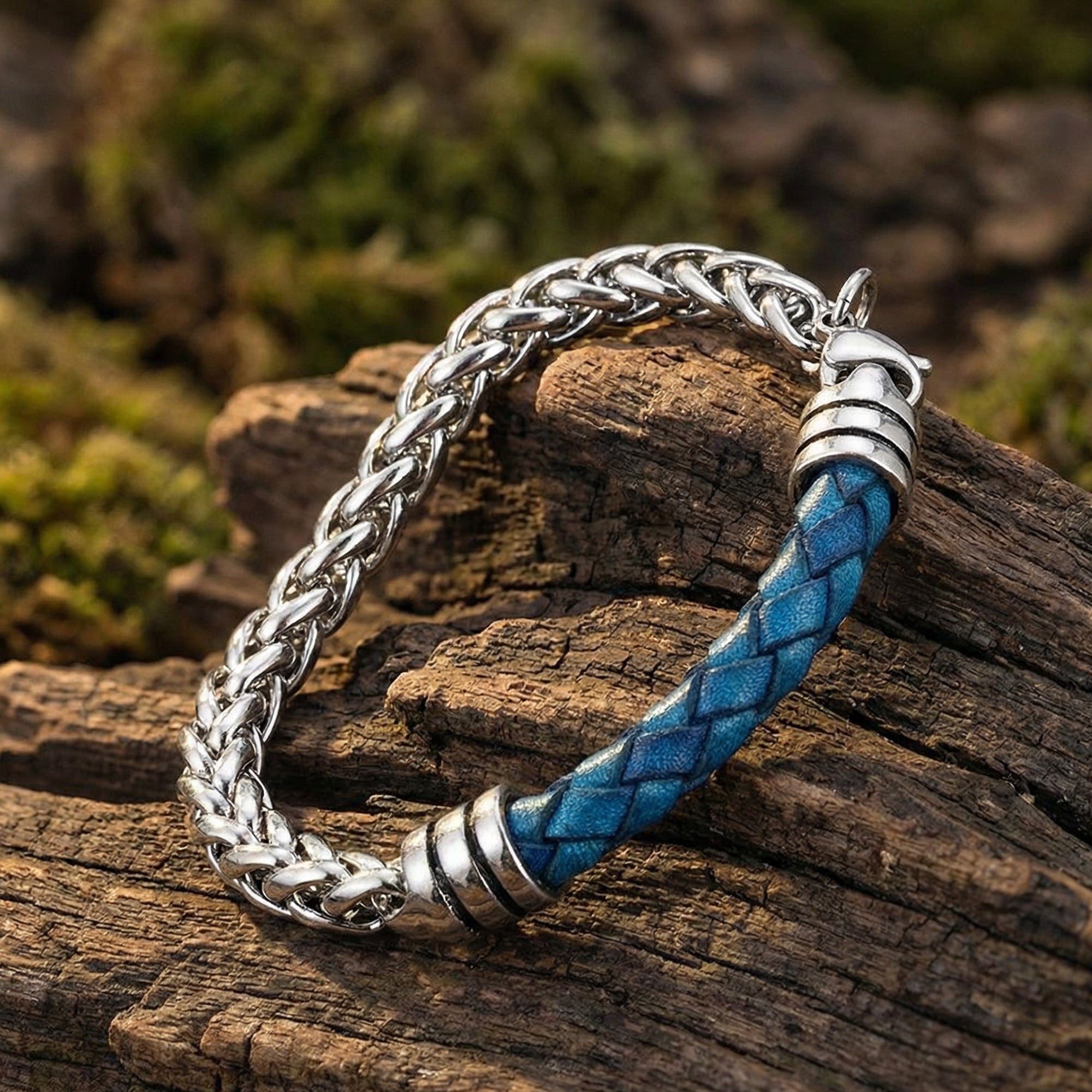 Maximan Daybreak men's blue leather steel chain bracelet laying on a wooden log outdoors