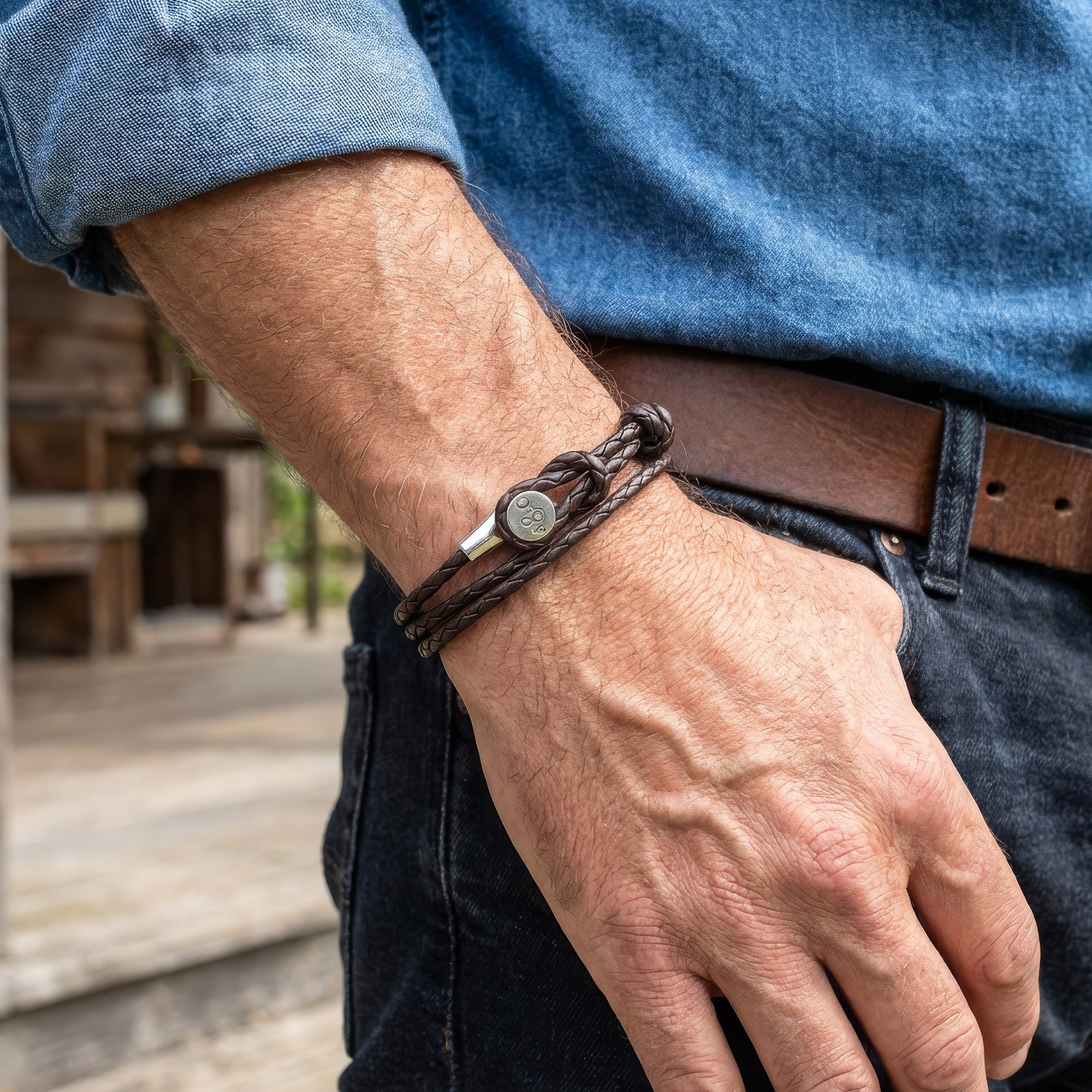 Man wearing Anchor & Crew Dundee sterling silver dark brown braided leather bracelet 