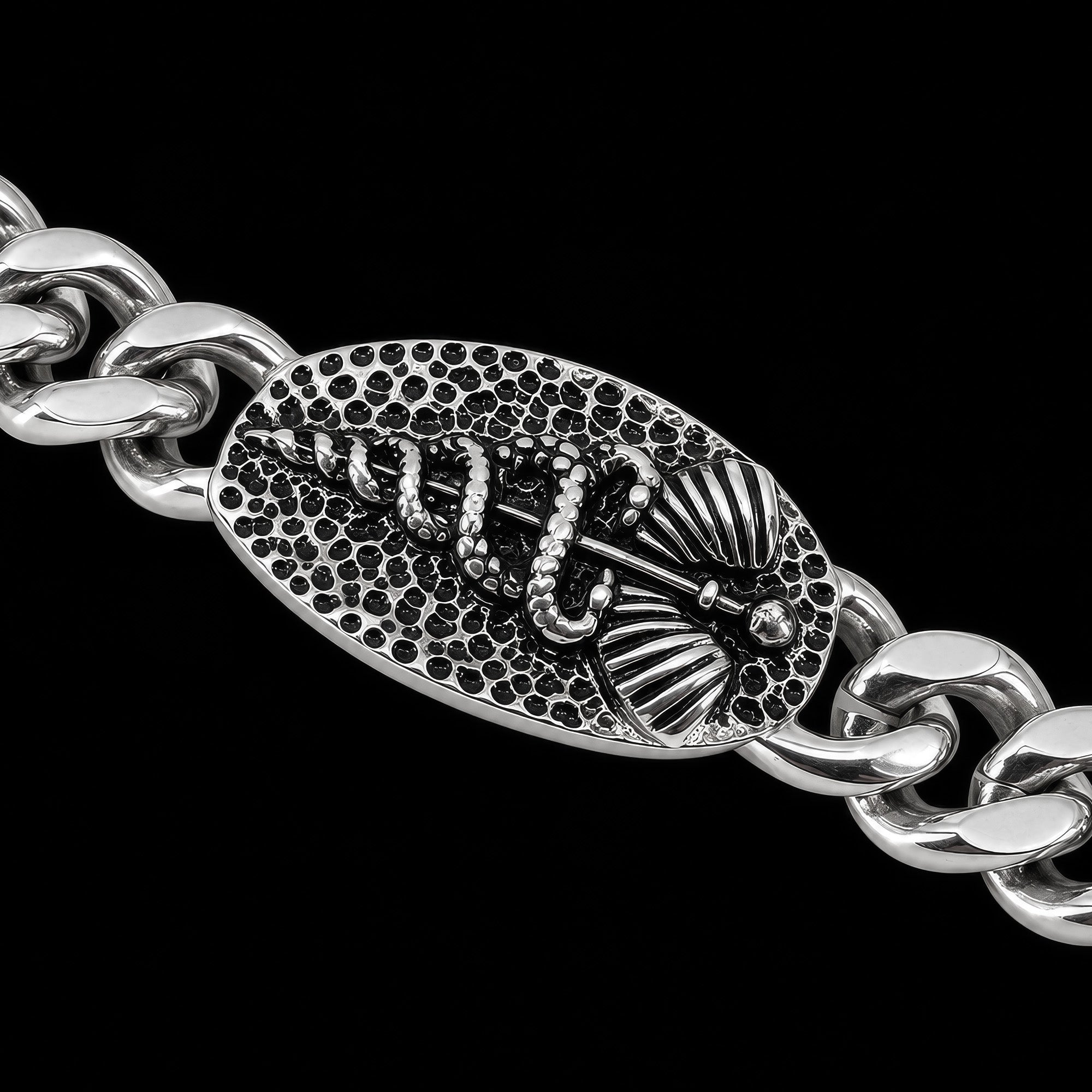 Close-up of a caduceus Cuban link men's stainless steel bracelet.