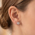 Woman wearing Engelsrufer filigree cage ball silver stud earrings.