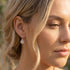 Woman wearing Engelsrufer cage ball silver hook earrings.