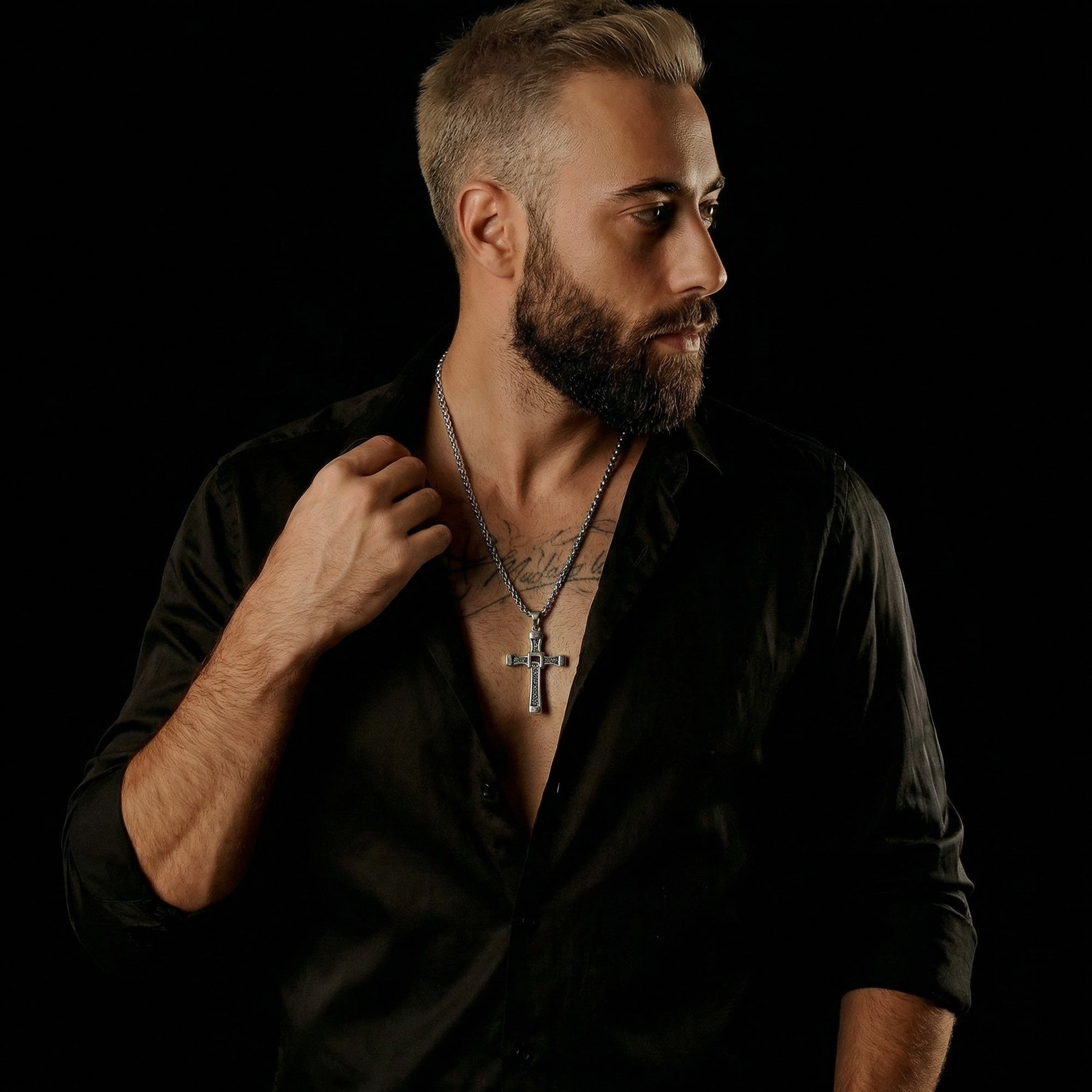 Beared man in black open-neck shirt wearing celtic runes swivel cross stainless steel necklace.