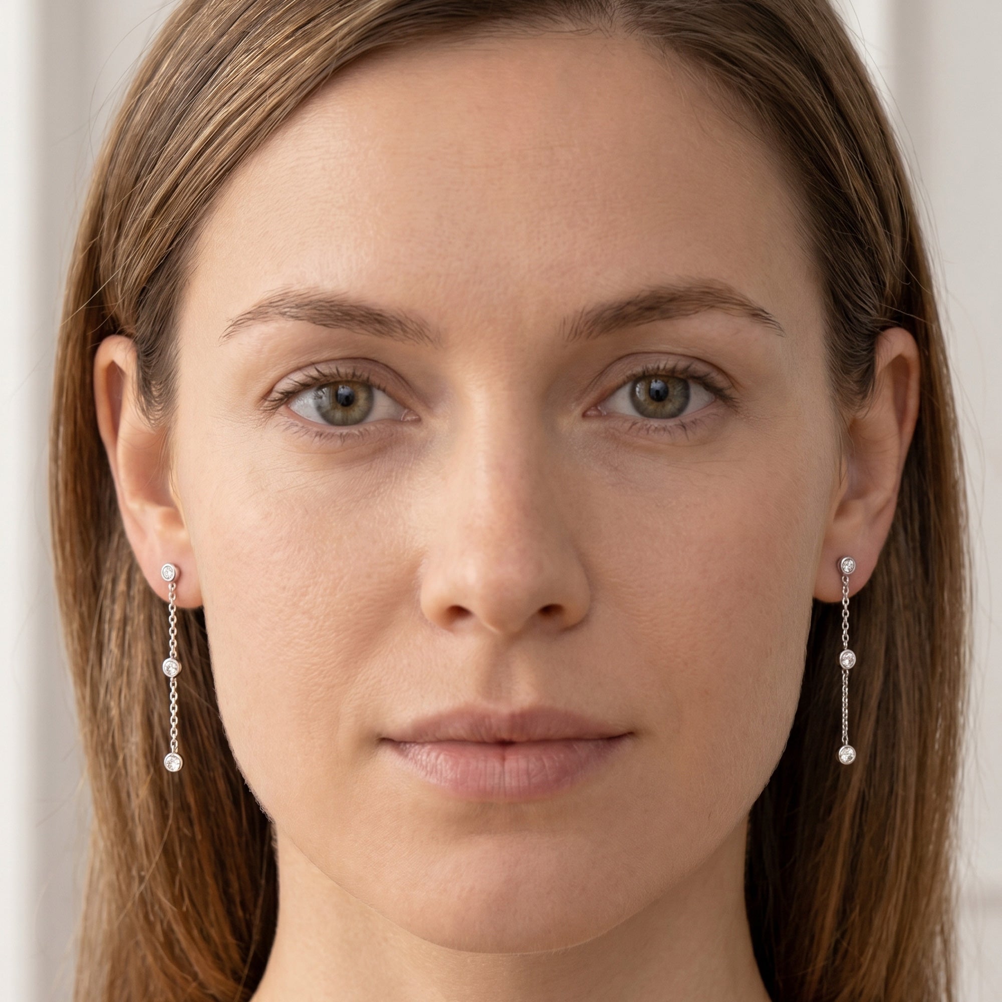 Woman wearing a pair of Engelsrufer chain sterling silver CZ earrings.