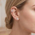 Woman wearing Engelsrufer cherub angel wing & moon mismatch earrings.