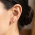 Woman wearing Engelsrufer pearl trio circle gold stud earrings.