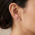 Woman wearing Engelsrufer circle pearl trio silver stud earrings.