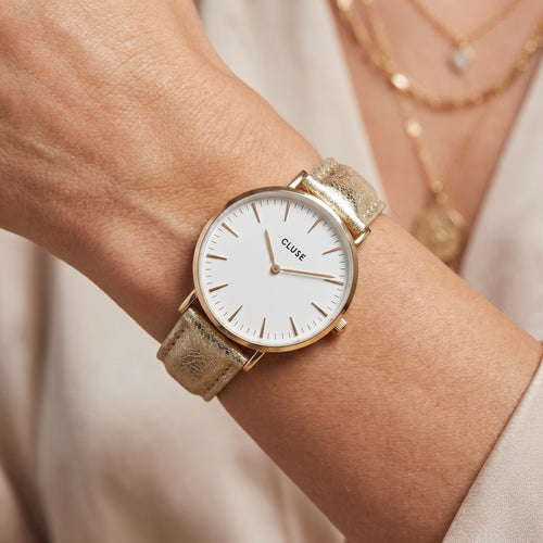 Woman wearing Cluse La Boheme gold white/gold metallic watch.