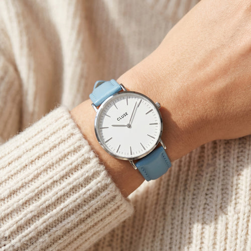 Woman wearing Cluse La Boheme silver white/pastel baby blue watch.