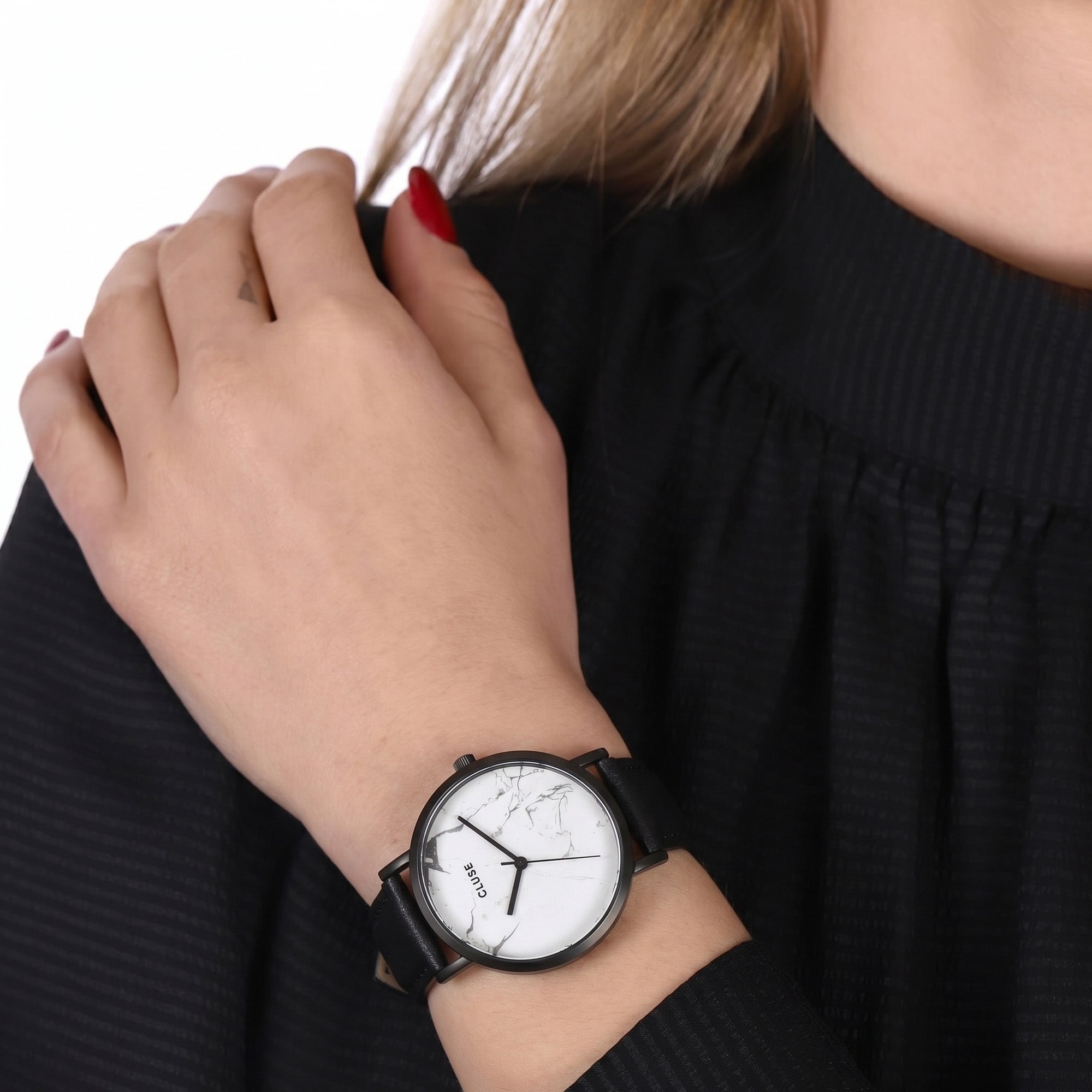 Woman wearing Cluse La Roche white marble/black watch.