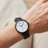 Woman wearing Cluse La Roche white marble/black watch on her wrist.