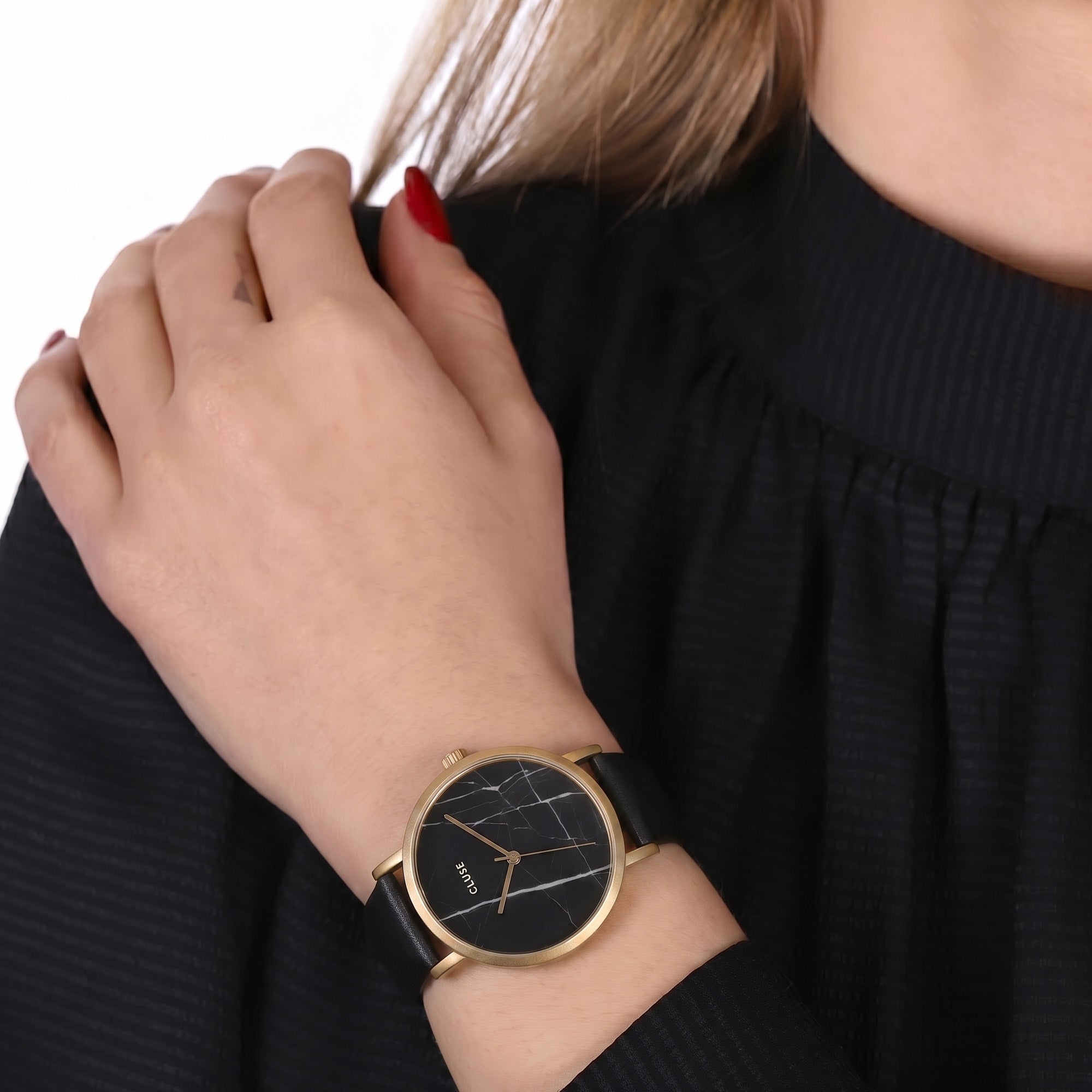 Woman wearing Cluse La Roche gold black marble/black watch.
