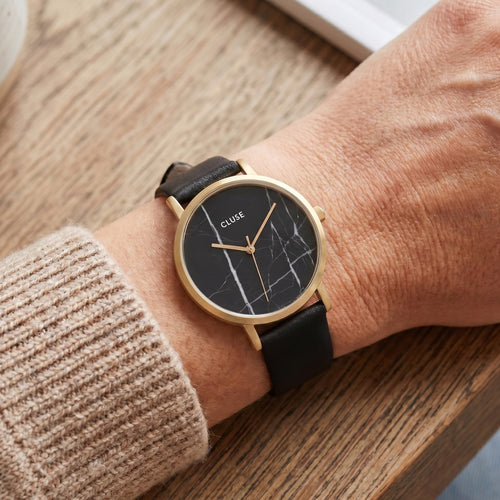Woman wearing Cluse La Roche gold black marble/black watch.