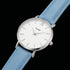 Close-up of Cluse Minuit silver/white baby blue watch.