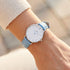 Woman wearing Cluse Minuit silver/white baby blue watch on her wrist.