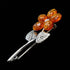 Side view of a cognac Baltic amber sterling silver flower brooch.